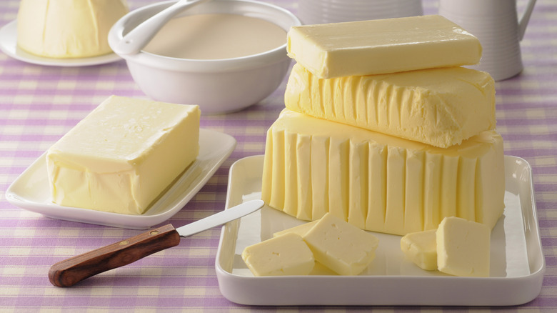 Several blocks of butter on purple gingham cloth