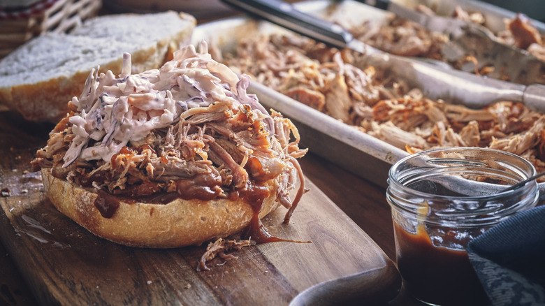 Messy pulled pork sandwich with coleslaw and bbq sauce