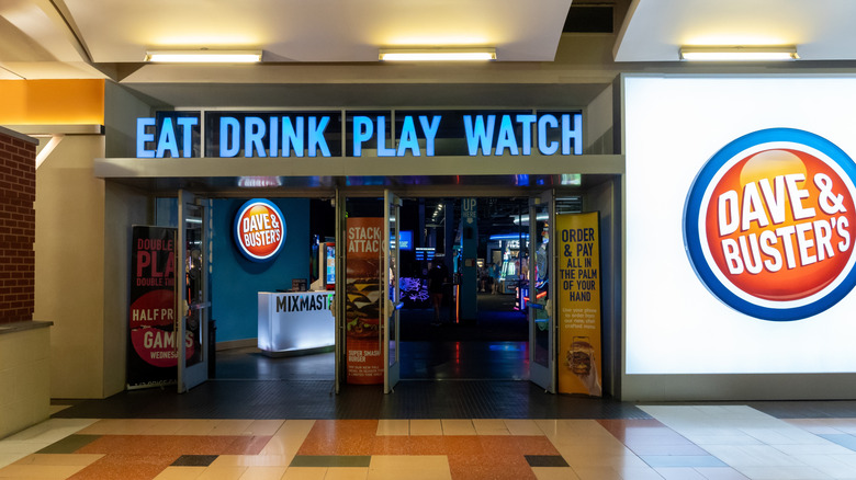 Dave & Buster's entrance with signs that say Eat, Drink,Play, Watch about doors