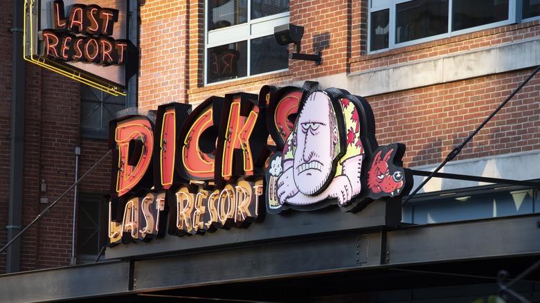 Dick's Last Resort neon sign with unhappy man mascot