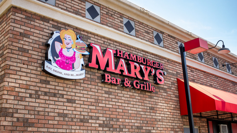 Hamburger Mary's restaurant brick exterior with logo of a drag queen holding a cheeseburger