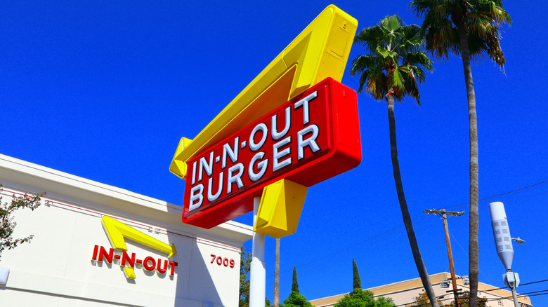 Bright In-N-Out signage under palm trees