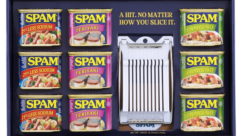 three cans each of three flavors of tinned meat in a gift box with a white meat slicer