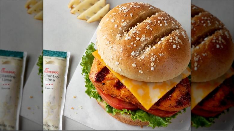 Grilled chicken sandwich from Chick-fil-A white butcher paper with a waffle fry and packet of cilantro lime sauce