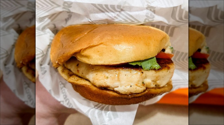 Person holding a Whataburger chicken sandwich wrapped in paper