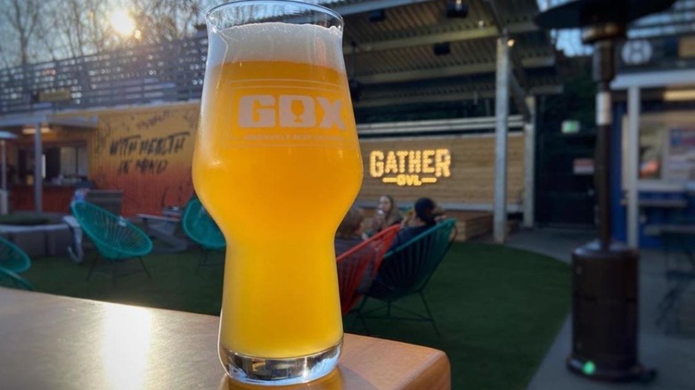 close up of beer glass served at Gather GVL market in Greenville, SC with market name logo in background