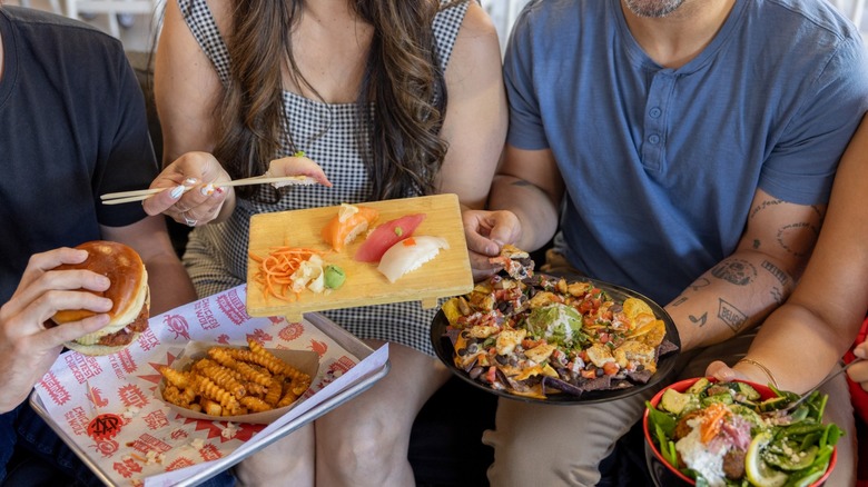 people enjoying various plated foods from Mother Road Market