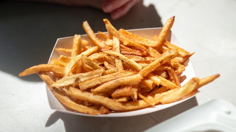 Close-up of small paper container of French fries