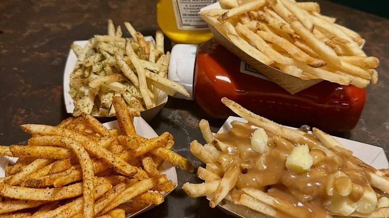 Various french fry baskets with a bottle of ketchup and mustard from Green Dot Stables