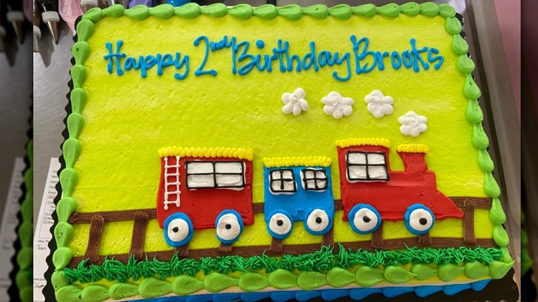 Green-frosted birthday sheet cake with a train design