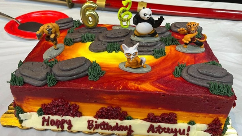 Birthday sheet cake with red and orange frosting and Kung Fu Panda figurines