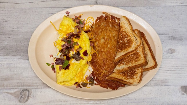 Omelet with toast and hash browns on plate from Frontier Diner