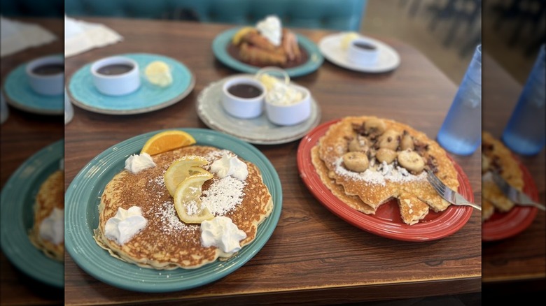 Plates with lemon ricotta and banana pancakes and stuffed french toast on table at Mandy's Breakfast House