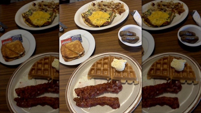Varoius breakfast dishes including waffles, bacon, sausages, toast and omelet on table at Two Brothers Cafe