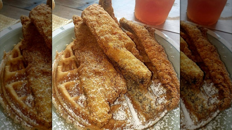 Fried fish and Waffles with powdered sugar on plate at Sunday's Cafe 64