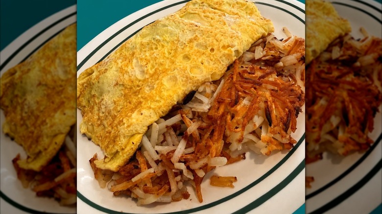 Omelet with side of hash browns on plate at Dagwood's Cafe