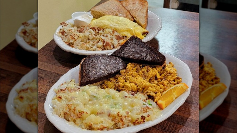 Various breakfast dishes, including toast, omelet, hash browns, and black molasses bread at Otis Cafe