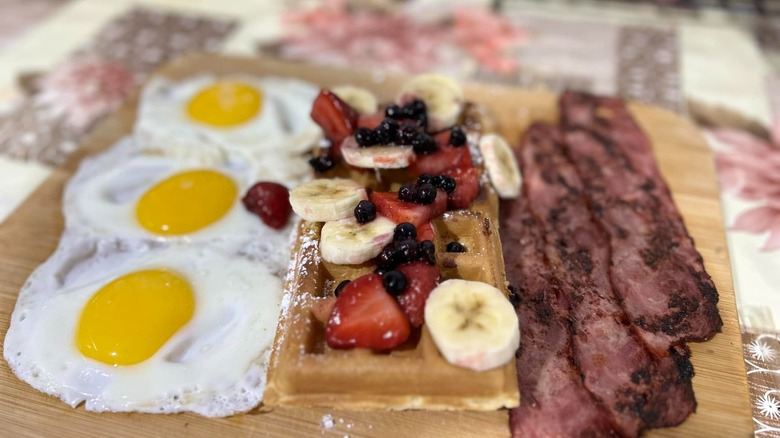 Belgium waffle platter with eggs, Belgian waffle with fresh fruits and breakfast meat at Three Boys Breakfast