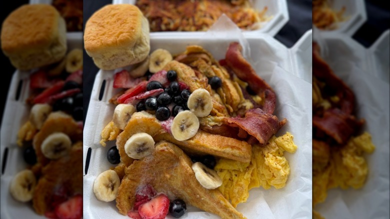 French Toast topped with eggs and bacon and fresh fruit, and a biscuit on the side at Joe's Cafe