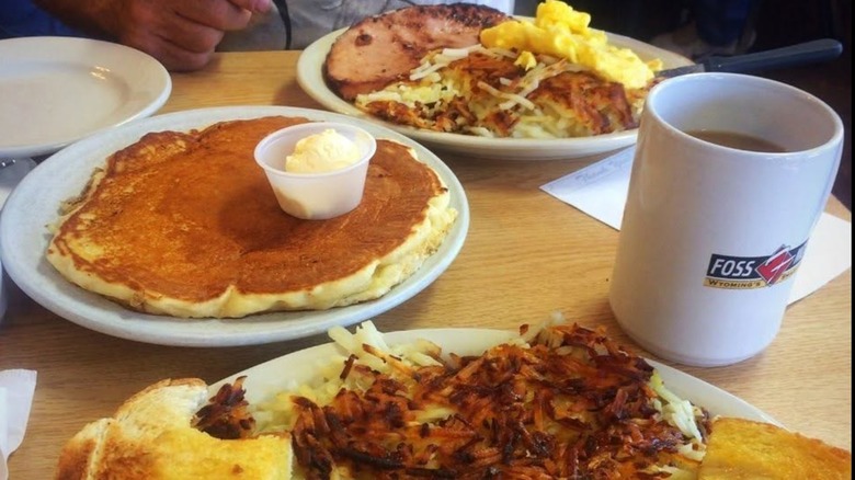 various breakfast plates with pancakes, hash browns, breakfast meats, scrambled eggs, toast, and a cup of coffee at Sherrie's Place