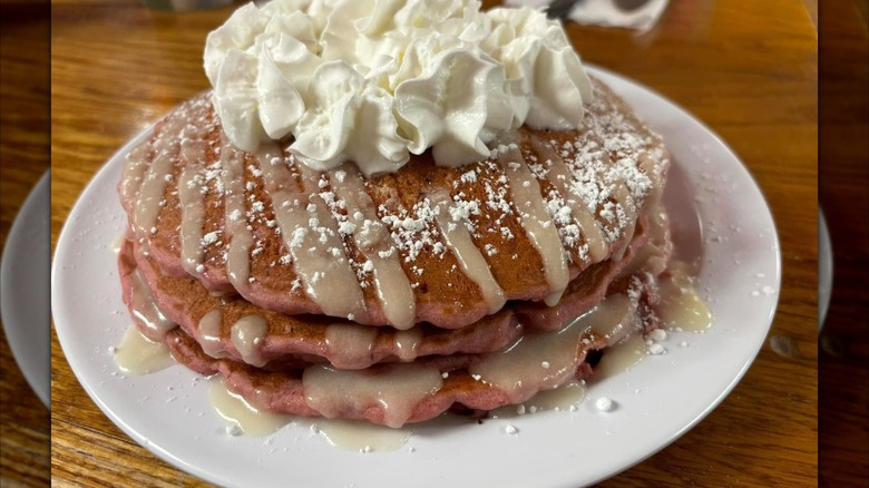 Cinnamon roll pancakes topped with whipped cream on plate at Skyway Jack's Restaurant