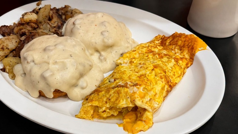 Homemade sausage gravy over biscuits, a cheesy omelet, crispy home fries, and coffee at Chick & Ruth's Delly