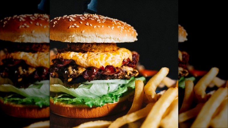 Trailer Park Burger with Cajun Fried Green Tomatoes, Jalapeno Pimento Cheese, Hickory Smoked Bacon, Iceberg Lettuce, Onion and side of French fries at Winnie's Tavern
