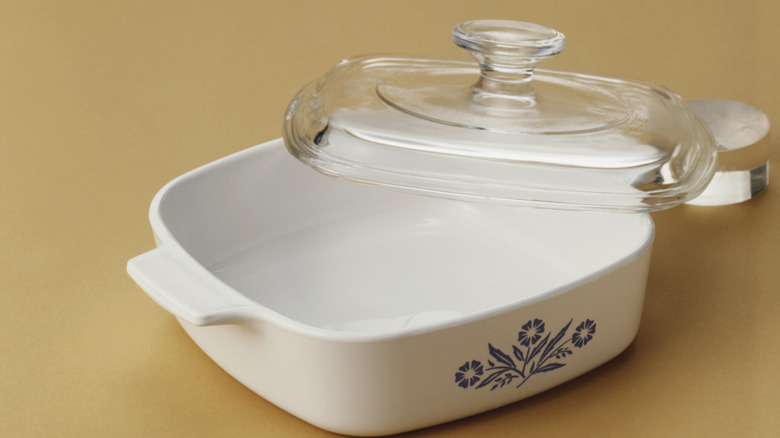 Blue cornflower pattern Corning Ware with a glass lid resting on one corner