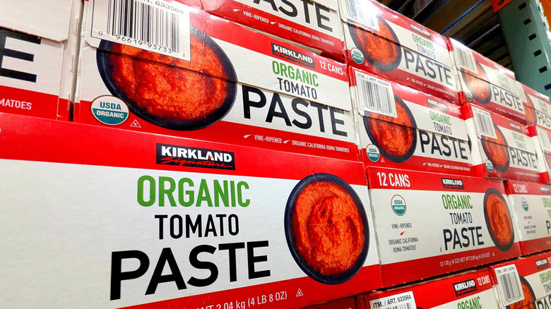 Boxes of Kirkland Signature organic tomato paste stacked on a shelf at Costco