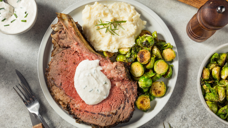 slice of prime rib with horseradish cream and potatoes