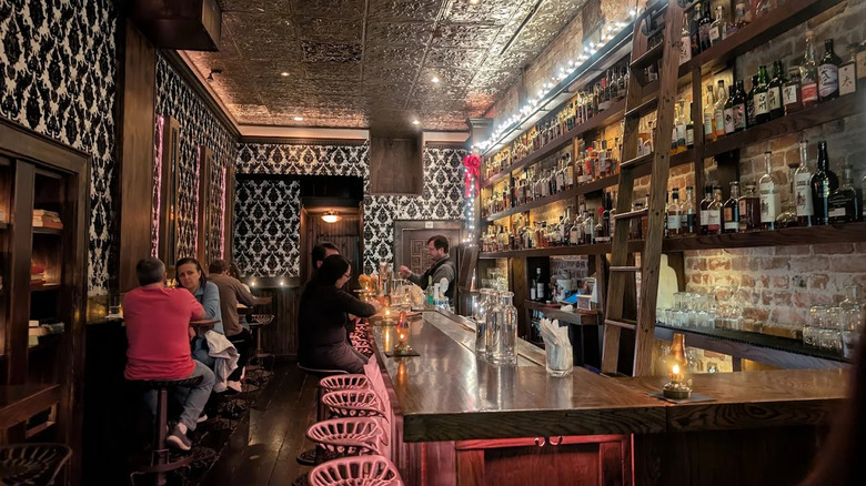 wooden bar with pink chairs and people