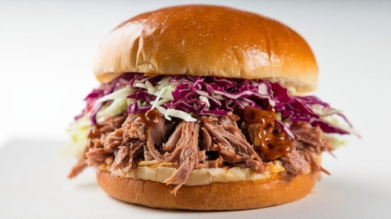 A delicious pulled pork sandwich with coleslaw on a soft bun, showcasing vibrant colors and textures
