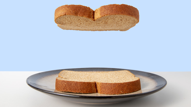 One slice of bread floating over another that rests on a plate