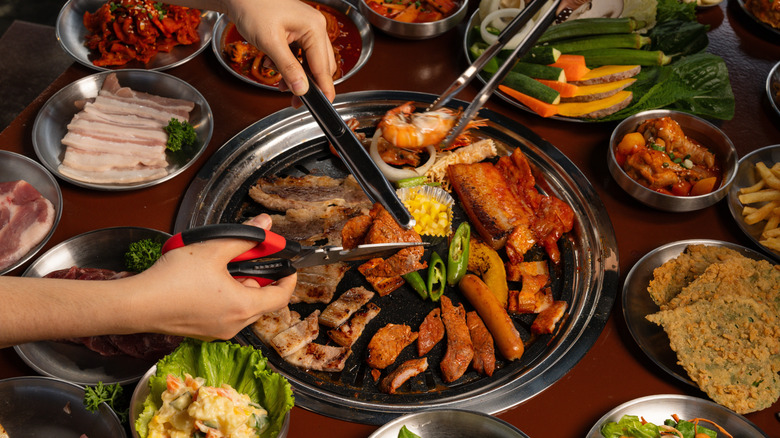 Cooking Korean barbecue with tongs