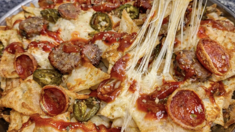 nachos topped with tomato sauce, mozzarella, and pepperoni