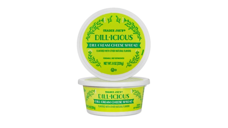 A green tub of Trader Joe's Dill-icious Dill Cream Cheese Spread on a white background