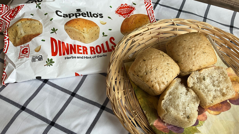 Square rolls sit in a basket next to the package of Cappello's dinner rolls on a black and white plaid cloth
