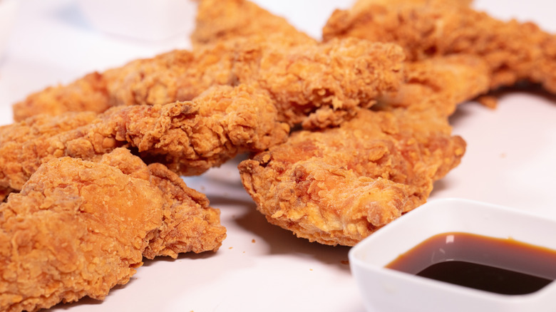 Chicken strips and sauce on a white background