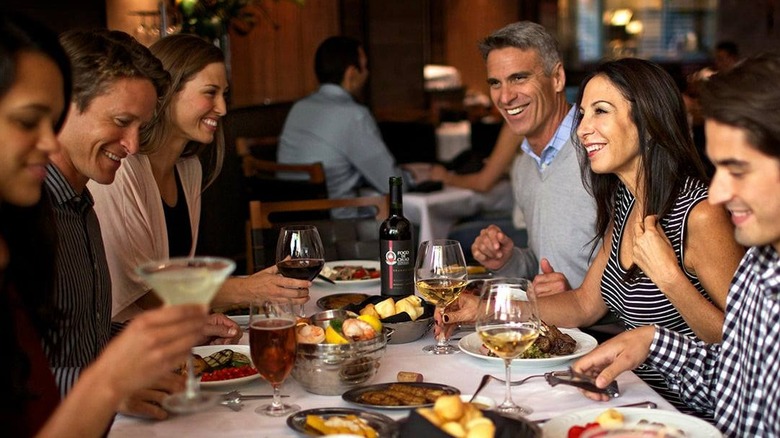People sitting at a table talking and eating