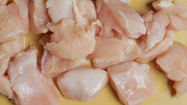 raw chicken breast pieces on cutting board