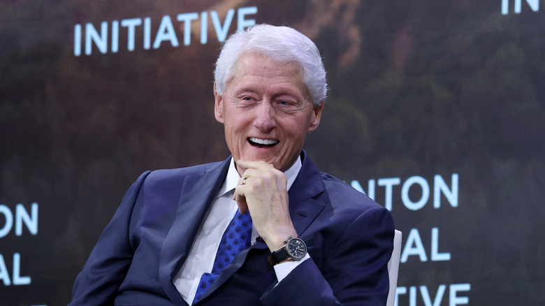 Bill Clinton smiling with his hand on his chin