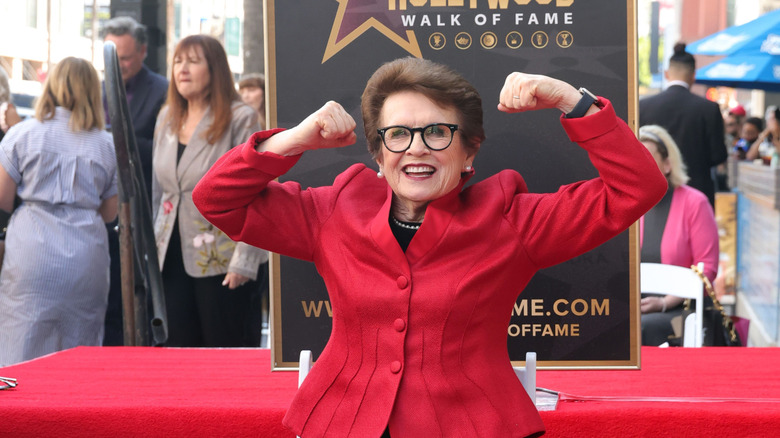 Billie Jean King seen smiling and flexing her muscles at the Hollywood Walk of Fame.