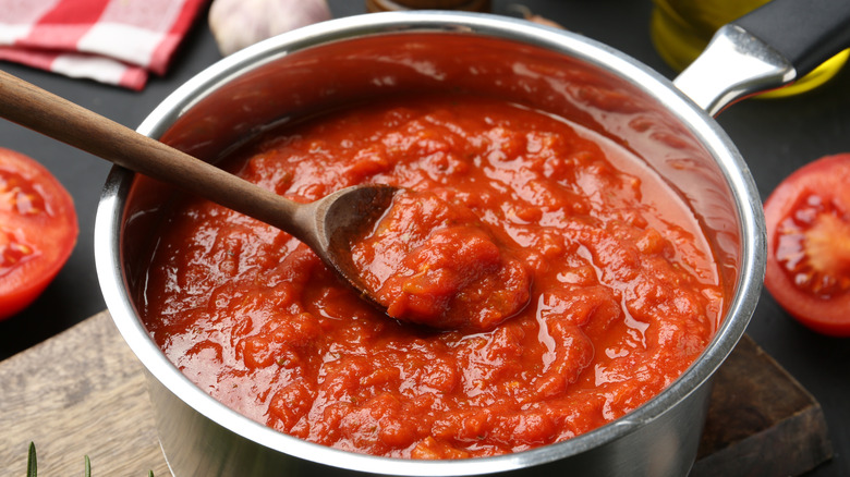 A close up of chunky tomato sauce in a pot on a counter