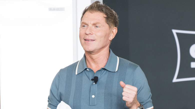 Chef Bobby Flay smiles while giving a cooking demonstration