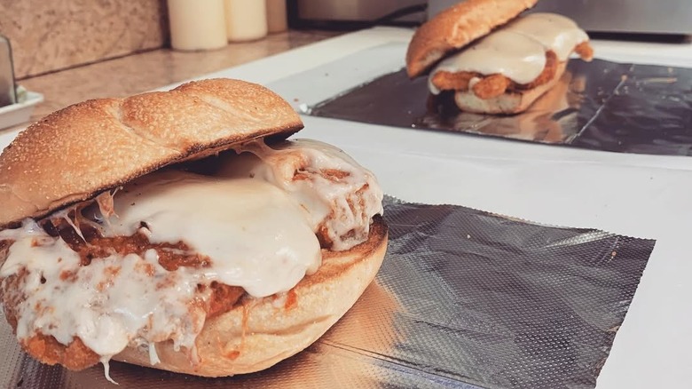 Two chicken parmesan sandwiches with melted cheese