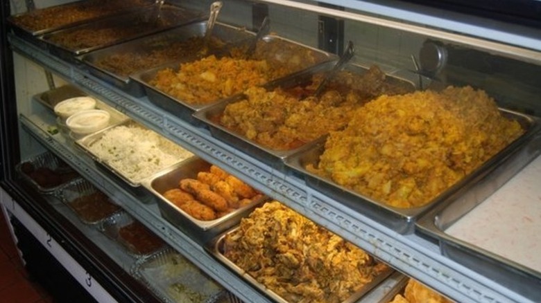 Spread of vegetarian food behind a counter at Punjabi Deli, NYC