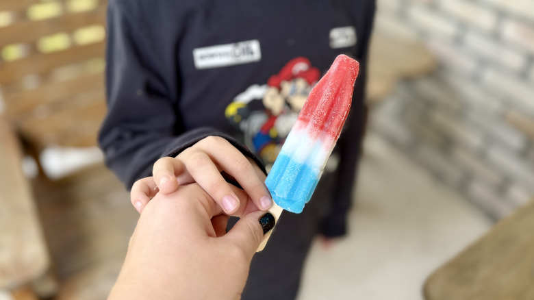 Handing popsicle to child