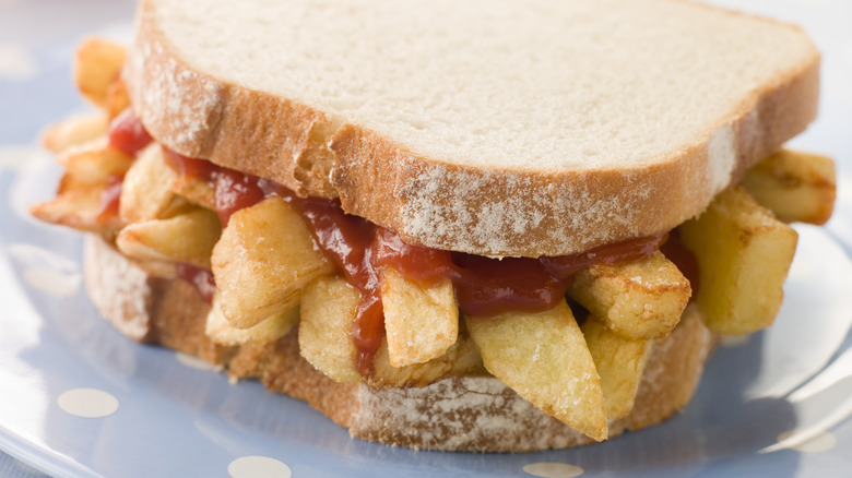French fry sandwich on white bread with ketchup on a plate