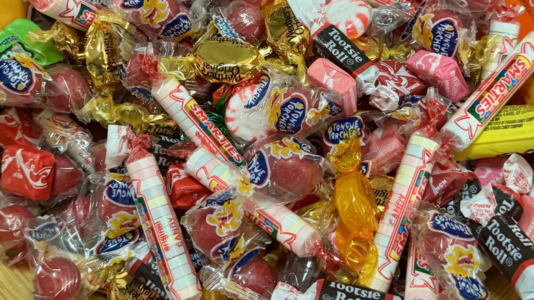 Close up of a pile of candies including butterscotch, peppermints, Smarties, and Starburst