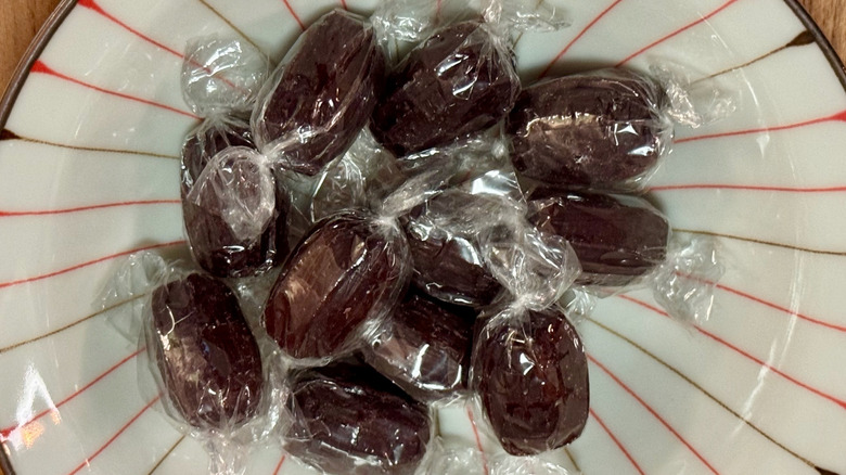 A small bowl filled with plastic wrapped root beer barrels